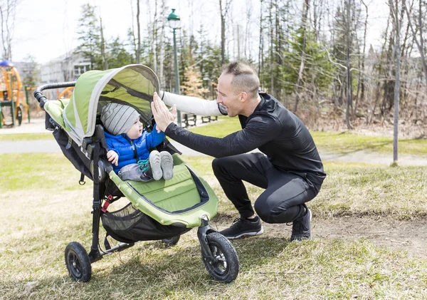 Far och son promenader i parken. Familjen och sport koncept. — Stockfoto