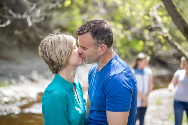 Pareja en la madera dando beso — Foto de Stock