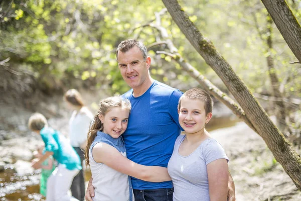 Jovem pai feliz com filhas ao ar livre — Fotografia de Stock