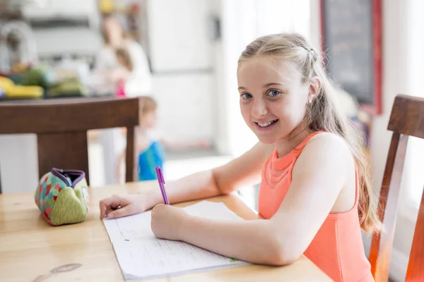 Linda chica adolescente haciendo la tarea en casa — Foto de Stock