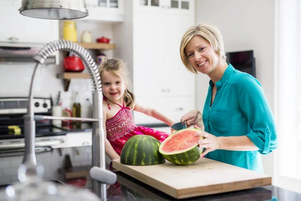 Mère et fille coupent pastèque dans la cuisine — Photo