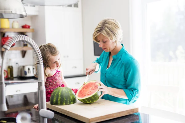 Anne ve kızı mutfakta karpuz kesmek — Stok fotoğraf