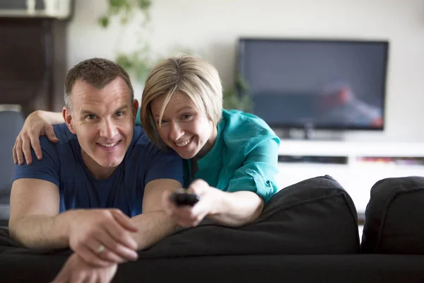 Paret ser tillbaka i vardagsrummet hemma — Stockfoto