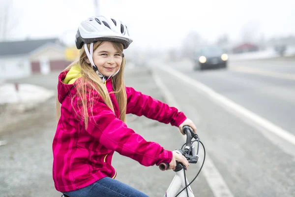 Bambina in bicicletta in una città — Foto Stock