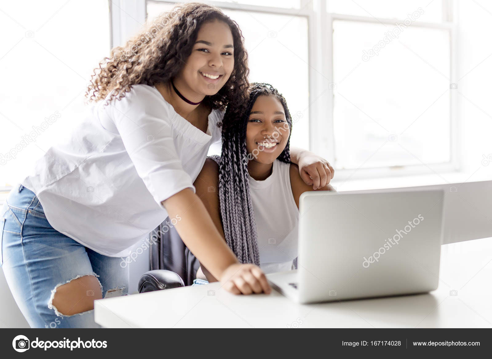 Two Teen At Desk In Her Office With Laptop Stock Photo Lopolo Two Teen At Desk In Her Office With Laptop Stock Photo