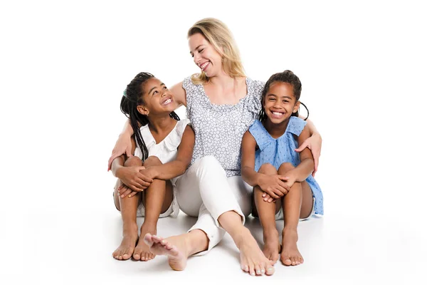 Afro twin child posing on a white background studio with white mother — Stock Photo, Image