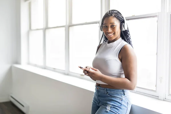 Ung tonåring vackra afroamerikanska kvinna har lyssnar på musik med hörlurar — Stockfoto
