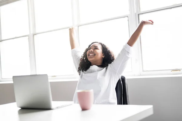 Teenager ved skrivebordet på hendes kontor med laptop - Stock-foto