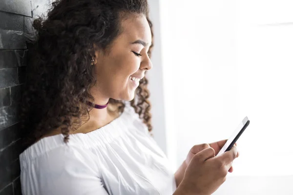 Guapo afroamericano adolescente usando un teléfono inteligente — Foto de Stock
