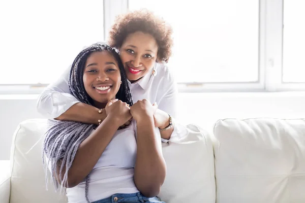 Affectionate mother and daughter sitting on sofa — Stock Photo, Image