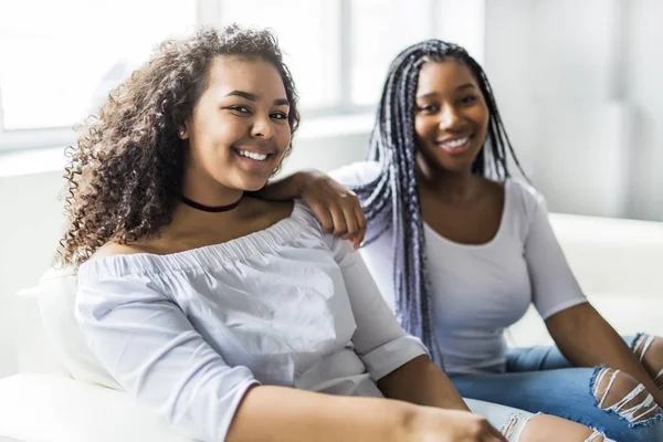 Kärleksfull mor och dotter som sitter på soffan — Stockfoto