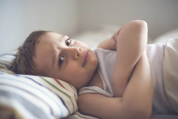 Młody chłopak na łóżku — Zdjęcie stockowe