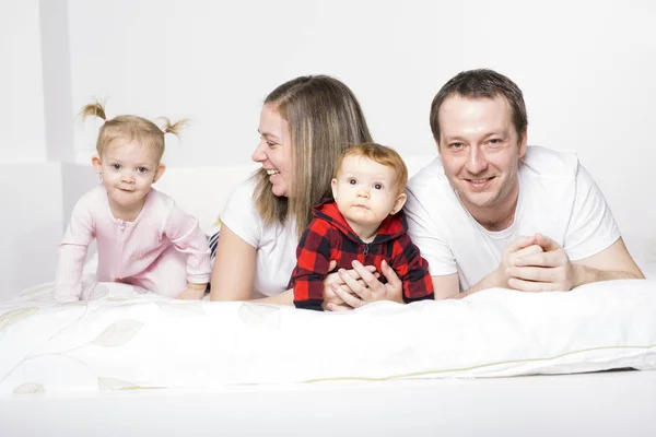 Familj från fyra personer spenderar glatt tid i sängar — Stockfoto