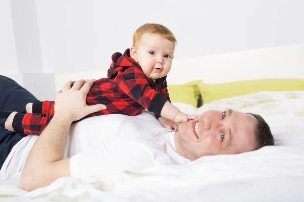 Vader spelen met babymeisje lag op bed — Stockfoto