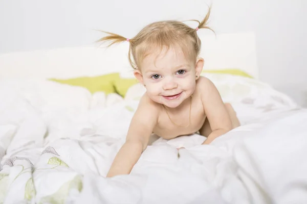 自宅のベッドで 2 歳のブロンドの女の子 — ストック写真