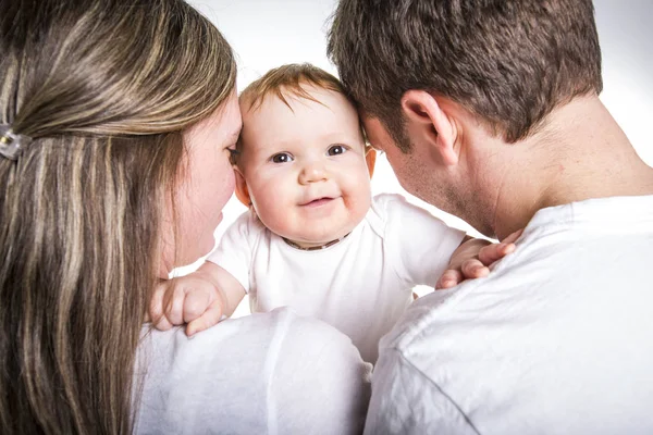 Joyeux jeune famille avec bébé en studio fond blanc — Photo