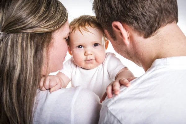 Joyeux jeune famille avec bébé en studio fond blanc — Photo