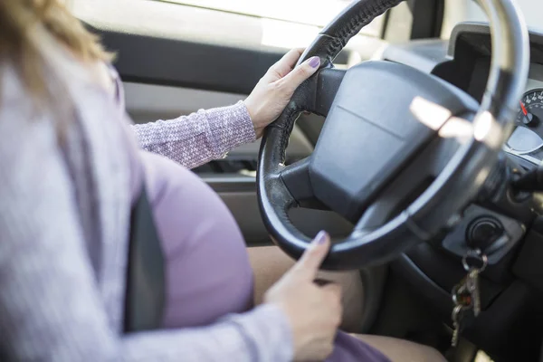 妊娠中の女性が車を運転してベルトをケリ — ストック写真