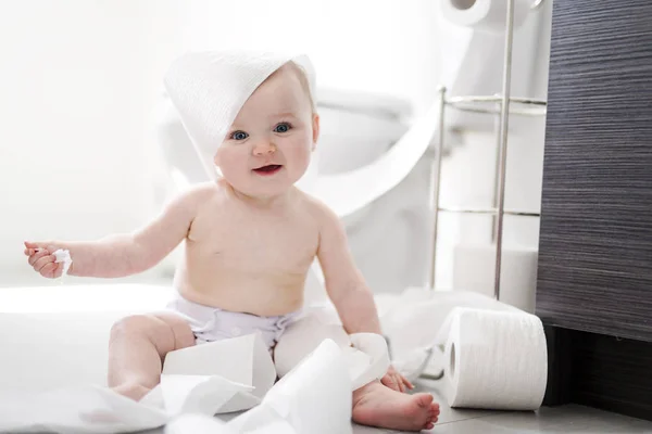 Peuter scheurt wc-papier in de badkamer — Stockfoto