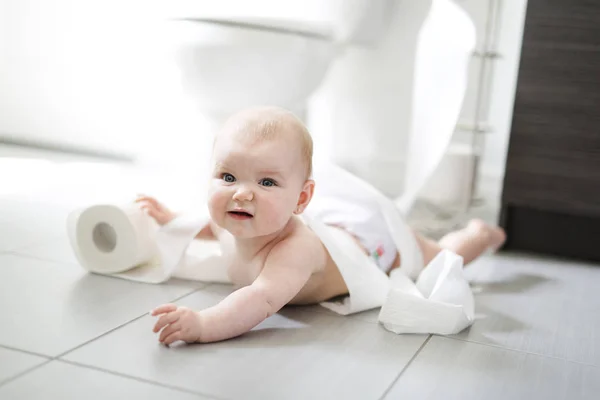 Niño rompiendo papel higiénico en el baño — Foto de Stock