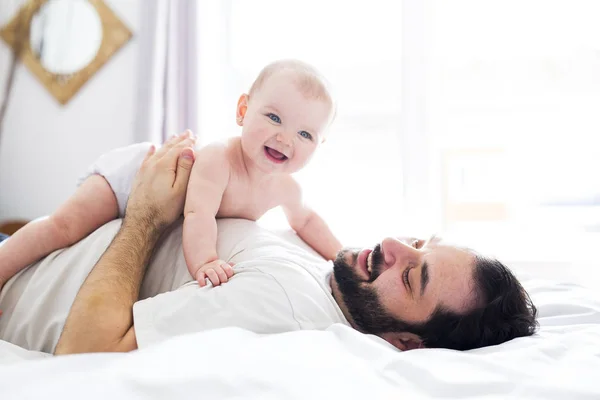 Joven padre feliz jugando con cama de bebé — Foto de Stock