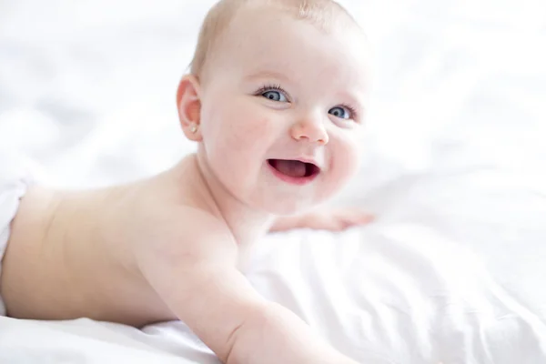 Baby meisje in wit beddengoed thuis kijken mooi — Stockfoto