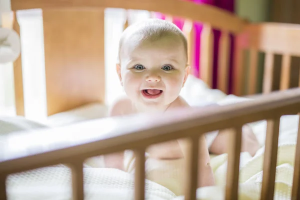 Nahaufnahme Porträt eines fröhlichen süßen Babys in der Krippe zu Hause — Stockfoto