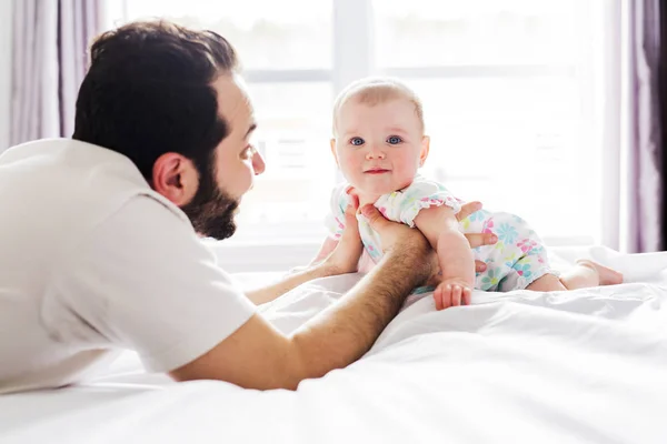 Joven padre feliz jugando con cama de bebé — Foto de Stock