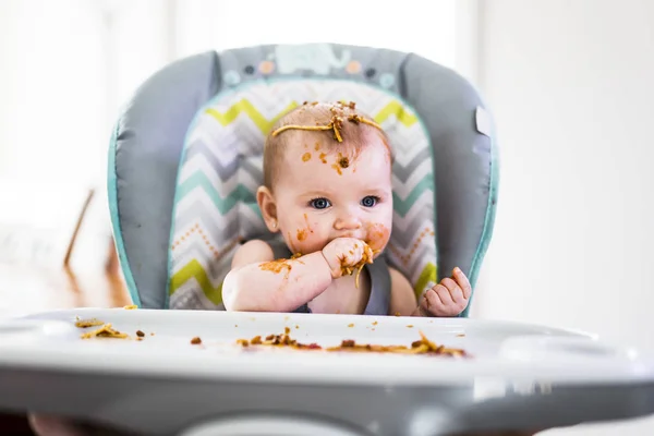 Pequeño bebé comiendo su cena y haciendo un lío — Foto de Stock