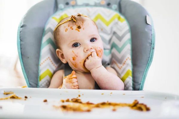 Kleine baby eet haar eten en maakt er een puinhoop van — Stockfoto