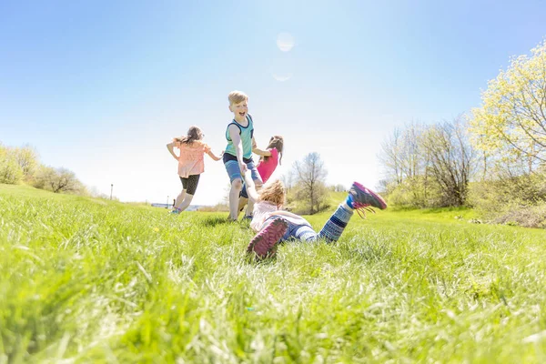 Grupp av barn har roligt på ett fält — Stockfoto