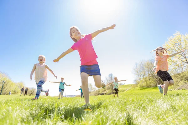 Grupp av barn har roligt på ett fält — Stockfoto
