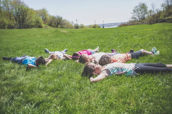 Grupp av vänner om i gräset — Stockfoto