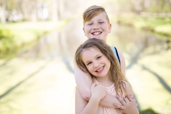 Porträtt av en liten flicka på gul bakgrund. med sin bror — Stockfoto