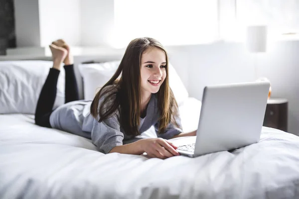 Tienermeisje liggend op Bed met behulp van een Laptop — Stockfoto