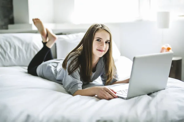 Tienermeisje liggend op Bed met behulp van een Laptop — Stockfoto