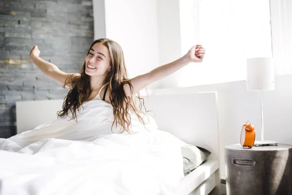 Beautiful young woman with long hair sleeping on bed in bedroom — Stock Photo, Image