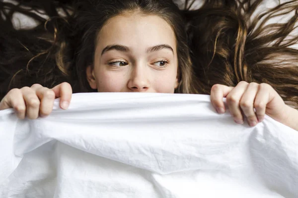 Wanita muda berambut cokelat mengejutkan dengan di tempat tidur — Stok Foto
