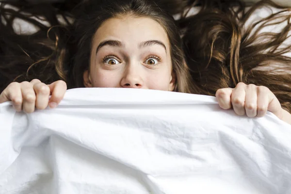Ung brunett chockerande kvinna med i sängen — Stockfoto