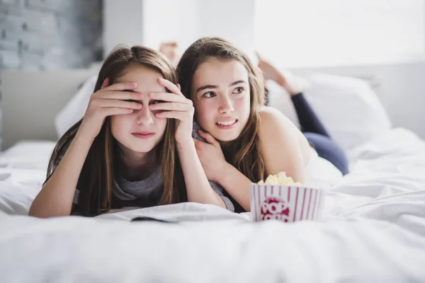 Tonårsflickor äta popcorn och titta på skräckfilm på tv hemma — Stockfoto