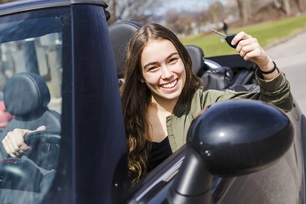 新しい車の中で若いブルネットの女性 — ストック写真