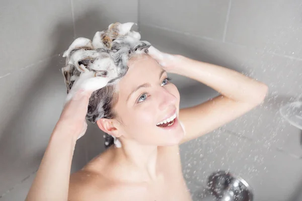 Mulher no chuveiro lavar o cabelo com shampoo — Fotografia de Stock