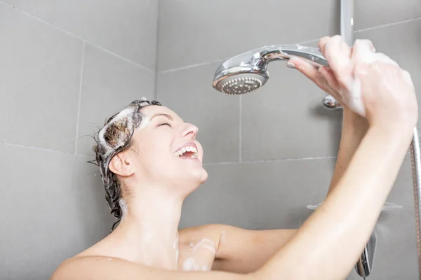 Mulher no chuveiro lavar o cabelo com shampoo — Fotografia de Stock