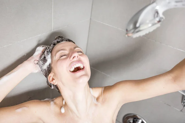 Kobieta pod prysznicem mycie włosów z szamponem — Zdjęcie stockowe