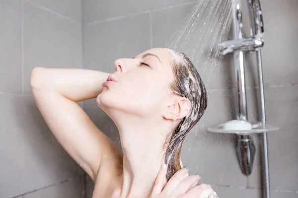 Mujer en la ducha lavando el cabello con champú —  Fotos de Stock