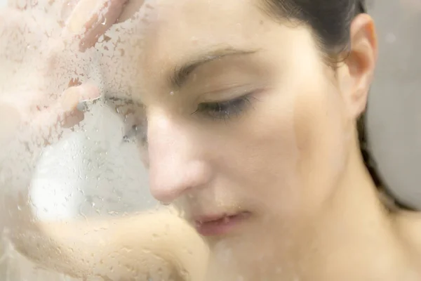 Mulher estressada apoiada na porta do chuveiro de vidro choroso — Fotografia de Stock