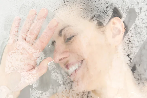 Retrato de cerca de una mujer divirtiéndose tocando el vidrio en la ducha —  Fotos de Stock
