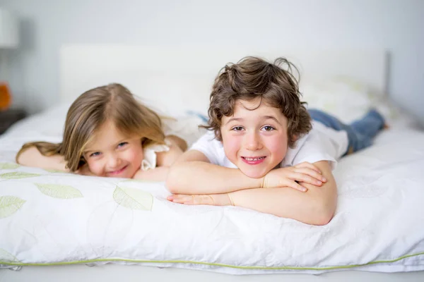 Irmão e irmã relaxando juntos na cama — Fotografia de Stock