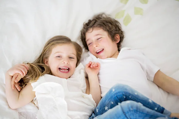 Broer en zus ontspannen samen in bed — Stockfoto