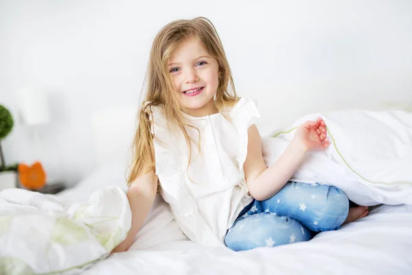 Adorable petite fille réveillée dans son lit — Photo